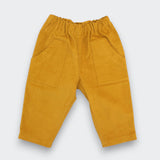 A pair of cider yellow cotton corduroy pants for kids with a front pocket and elastic waistband.