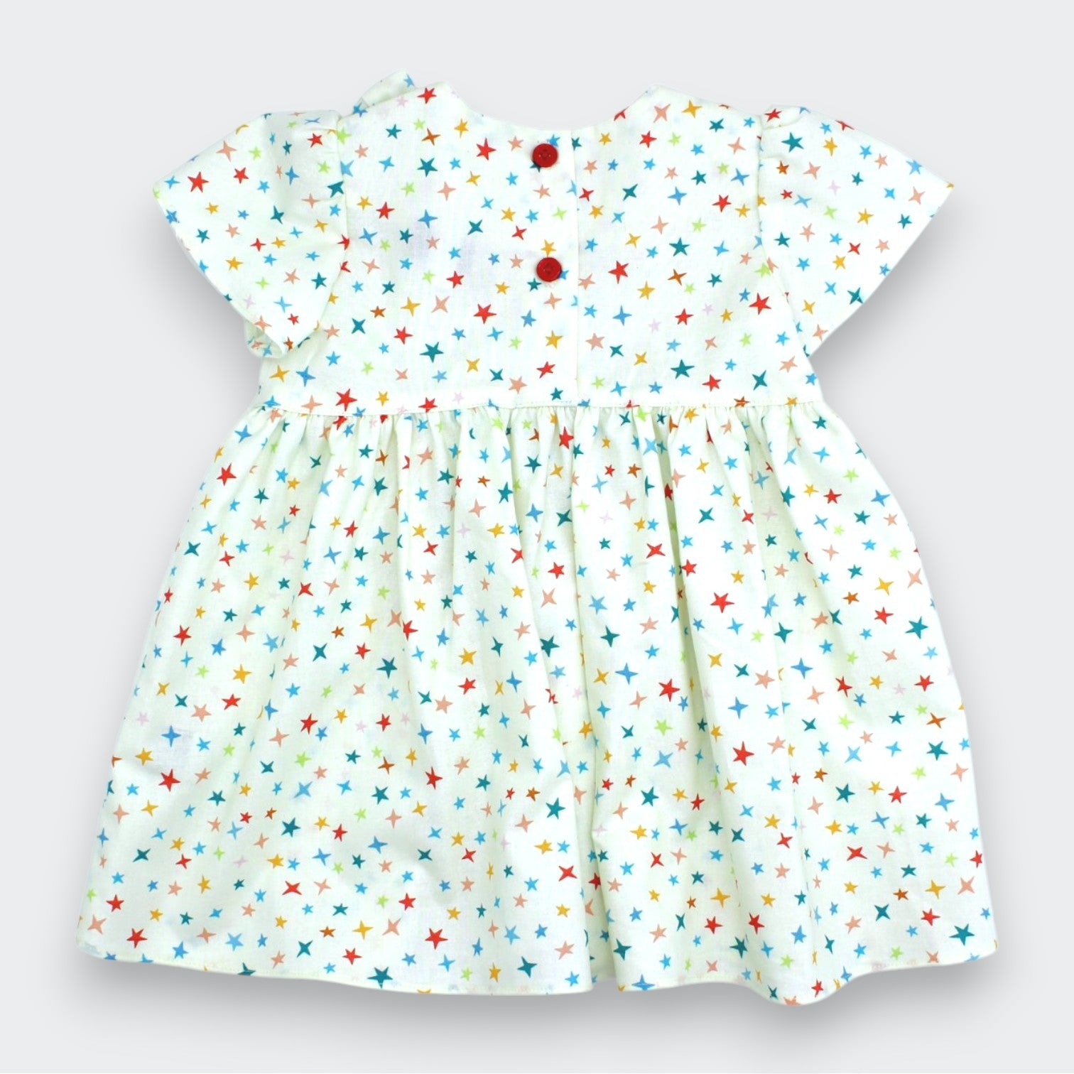 Children's dress with colorful star pattern on a light background