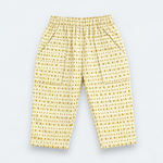 Yellow and white patterned pants with an elastic waistband and side pockets, laid flat on a light gray background.