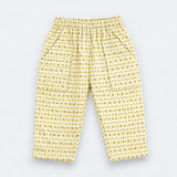 Yellow and white patterned pants with an elastic waistband and side pockets, laid flat on a light gray background.