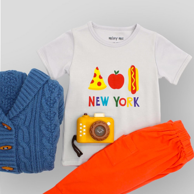 Blue kids cardigan with grey t-shirt, orange pants and wooden toy camera