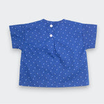 Blue children's shirt with white stars on a light gray background