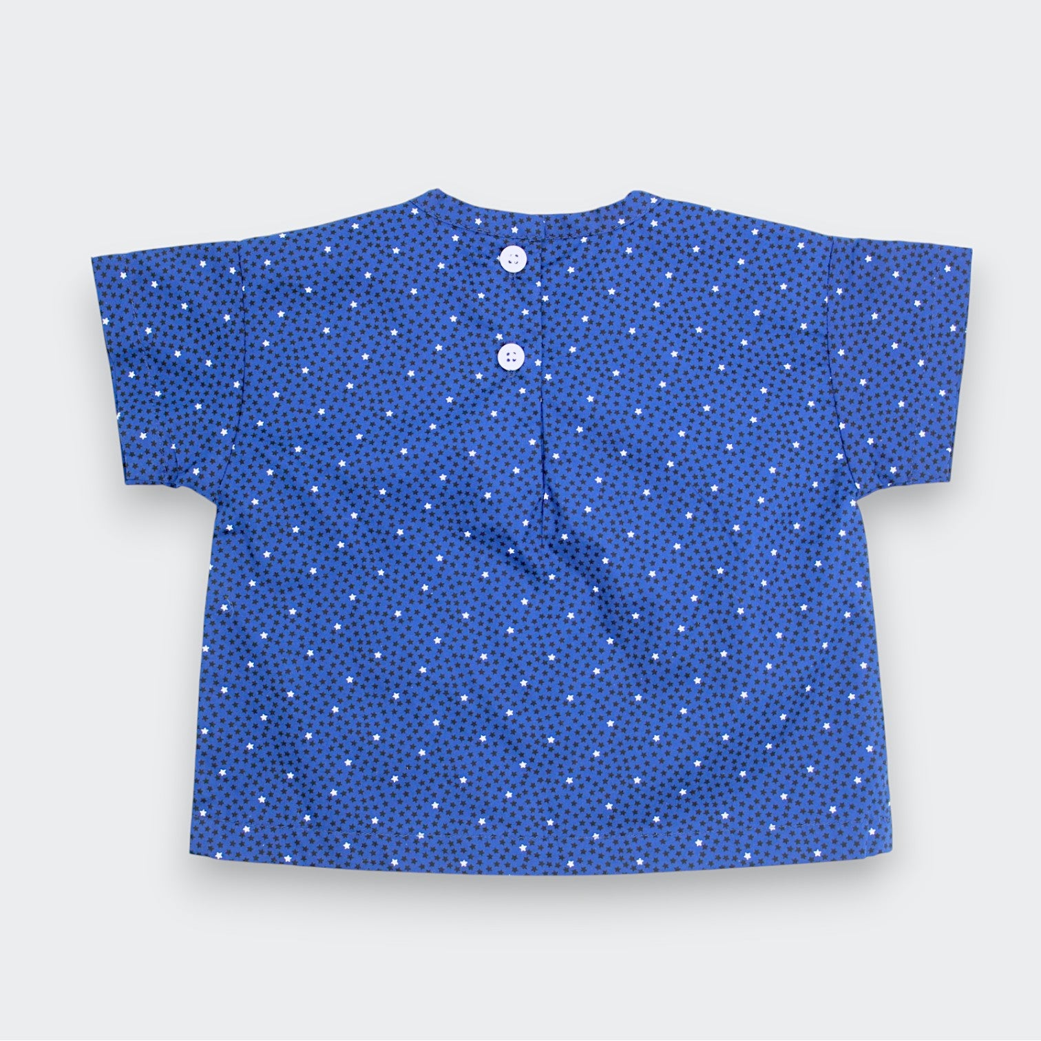 Blue children's shirt with white stars on a light gray background