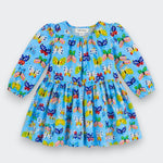 A light blue long-sleeve baby dress with an all-over colorful butterfly print, featuring a gathered waist and puffed sleeves, shown flat on a light gray background.