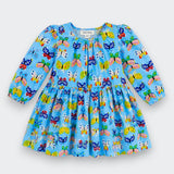 A light blue long-sleeve baby dress with an all-over colorful butterfly print, featuring a gathered waist and puffed sleeves, shown flat on a light gray background.