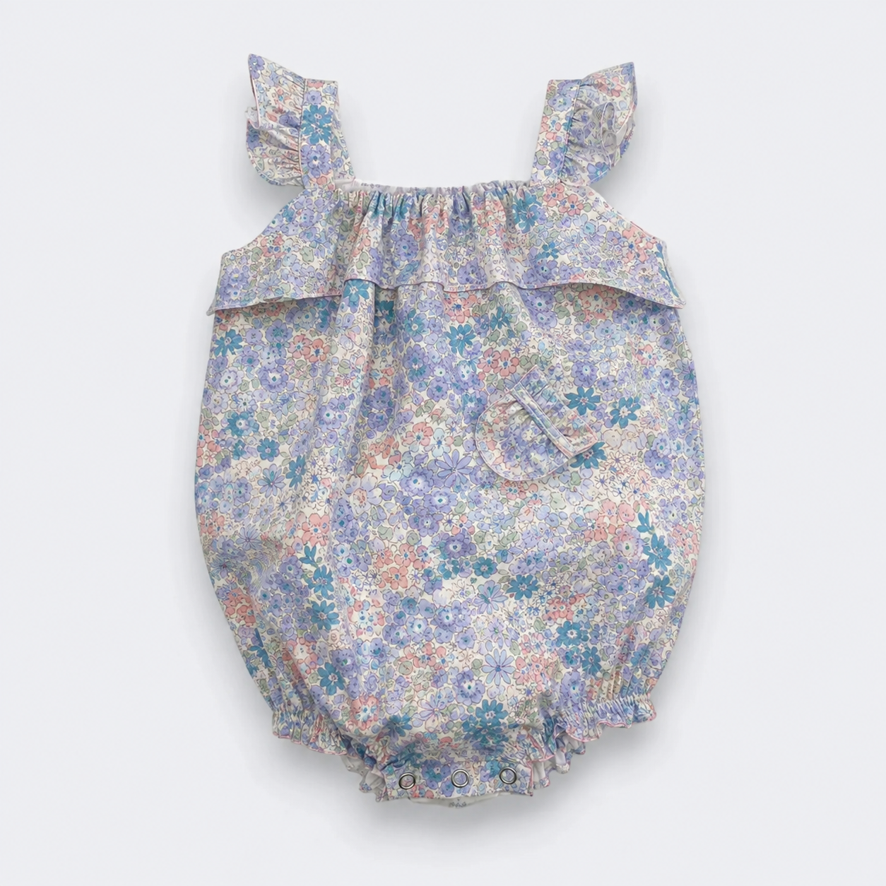A baby bubble romper with a delicate multicolor floral print in shades of blue, purple, pink, and green on a light background. It features ruffled shoulder straps, a ruffled chest detail, and a ruffled hem, shown against a plain light gray background.