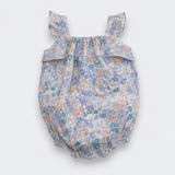 A baby bubble romper with a delicate multicolor floral print in shades of blue, purple, pink, and green on a light background. It features ruffled shoulder straps, a ruffled chest detail, and a ruffled hem, shown against a plain light gray background.