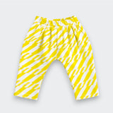 A pair of Little Moony children's pants featuring a bold yellow and white diagonal zigzag pattern, displayed flat against a light gray background.