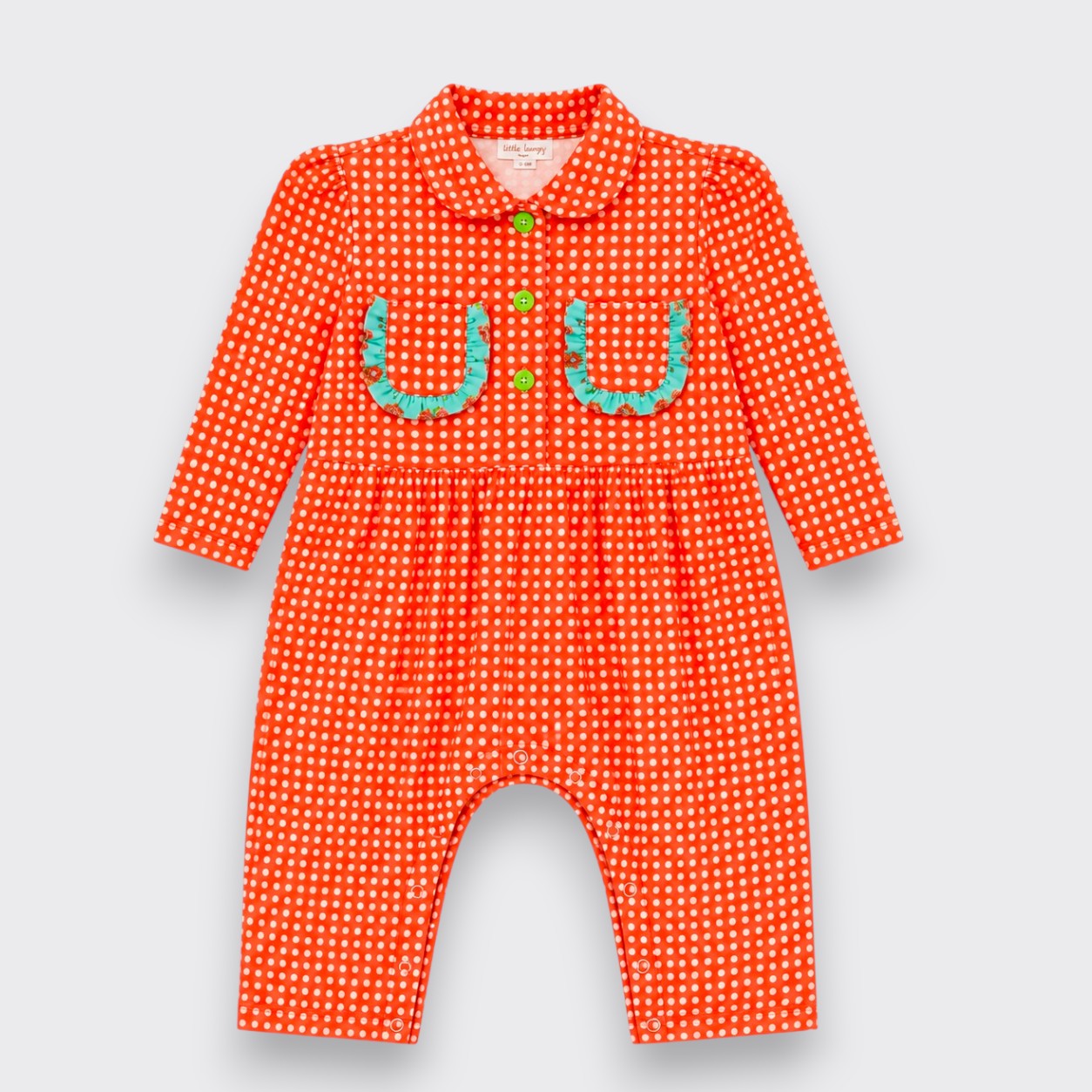 A baby romper in bright orange with a white polka dot pattern, featuring a Peter Pan collar, long sleeves, and a decorative applique chest design resembling two horseshoes in light blue-green with small green buttons.