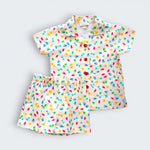 A two-piece baby outfit set consisting of a short-sleeve button-up shirt and matching shorts, both featuring a colorful tropical leaf print on a cream-colored background. The shirt has a collar and button-down front, while the shorts have an elastic waistband.