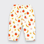 Little Moony White elastic-waist pants with an all-over watercolor fruit print of oranges, bananas, and pears, shown flat on a light gray background.