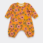 A baby long-sleeve romper in bright yellow-orange with a pink and green floral print, featuring a small yellow pouch pocket on the chest, laid flat on a light gray background.