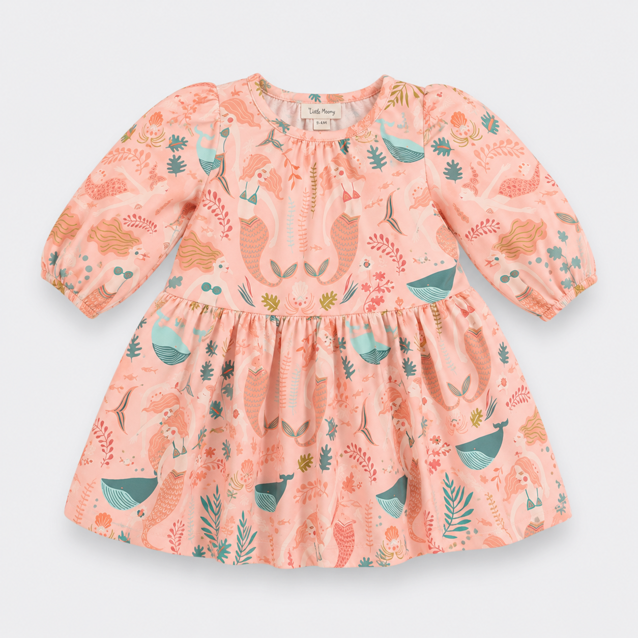 Little Moony gir's long-sleeve dress by Little Mary, featuring a peach-pink base with a whimsical print of fairies, woodland plants, and blue birds. The dress has a smocked bodice, puffed sleeves, and a gathered skirt, shown flat on a light gray background.