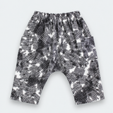 Black and white patterned harem pants with an elastic waistband, laid flat on a light gray background.