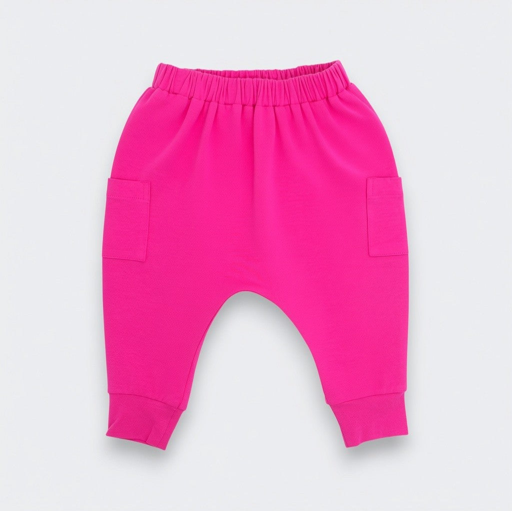 Bright pink baby jogger pants with an elastic waistband, side pockets, and cuffed ankles, shown flat on a light gray background.