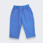 A pair of children's pants featuring a vibrant teal and purple striped pattern, laid flat against a light gray background.
