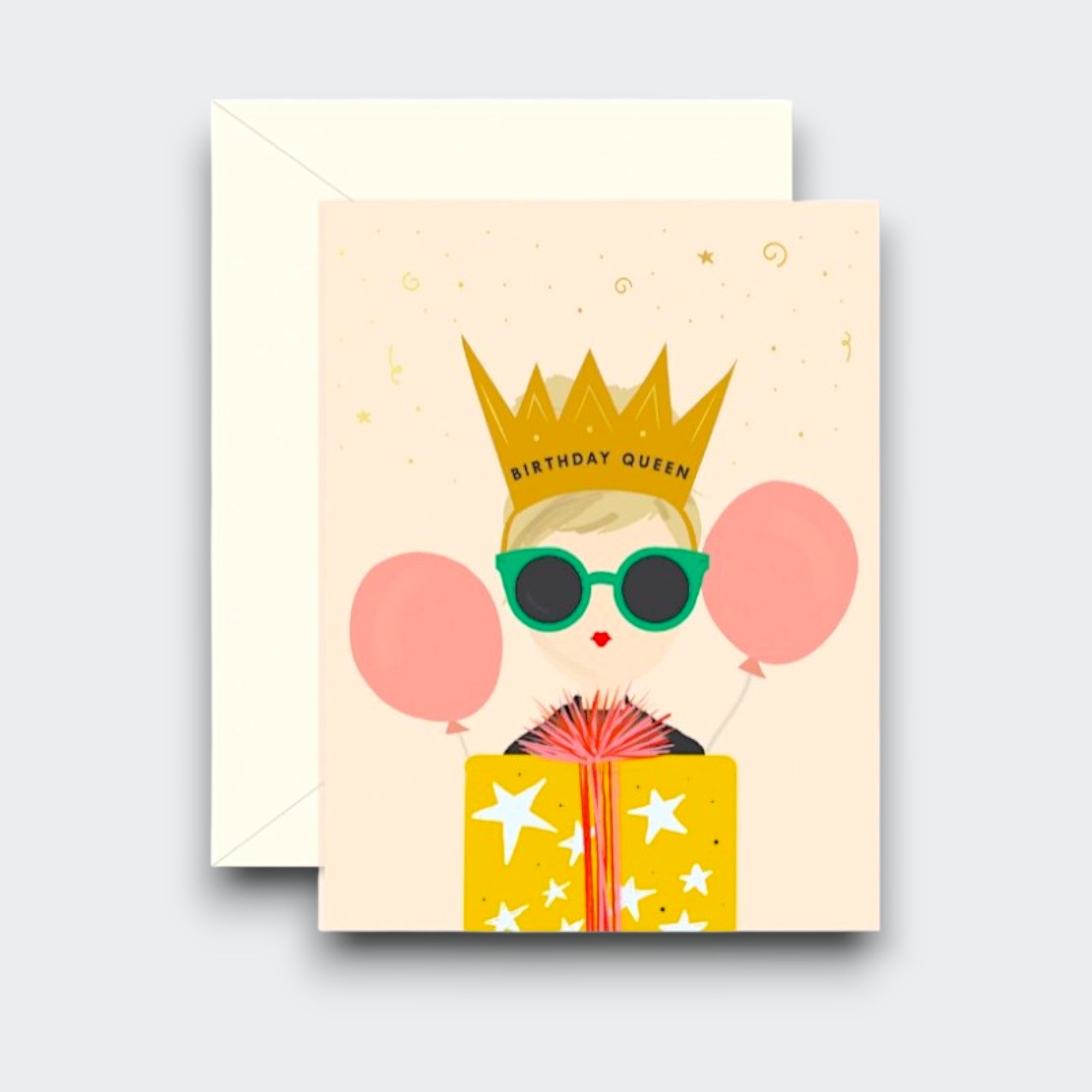 A birthday card featuring a “Birthday Queen” in a gold crown and green sunglasses, with pink balloons and a yellow gift decorated with white stars. A cream envelope sits behind it.