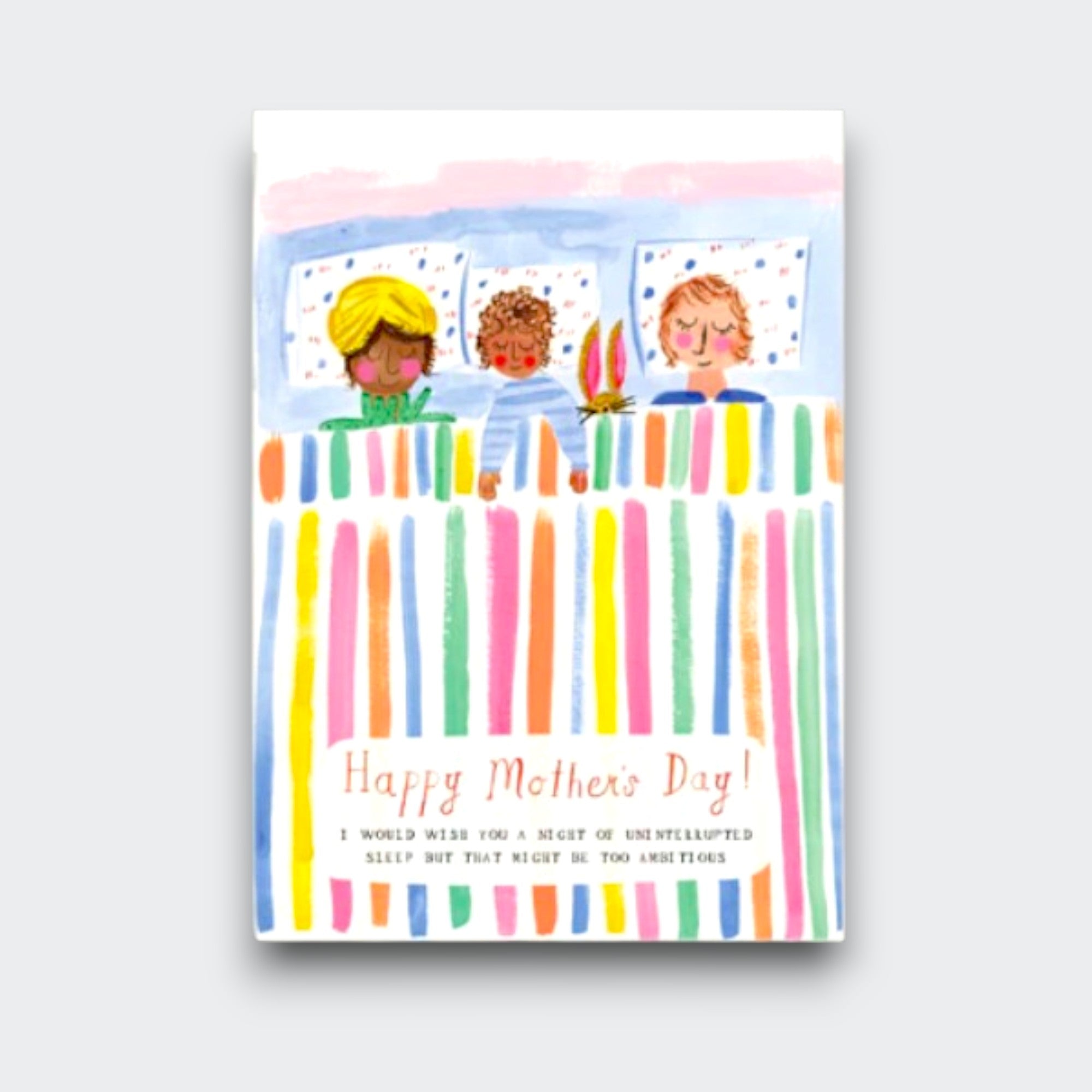 A Mother’s Day card showing a mother asleep in bed between two children under a colorful striped blanket. It reads “Happy Mother’s Day!” with a small message below wishing her uninterrupted sleep.