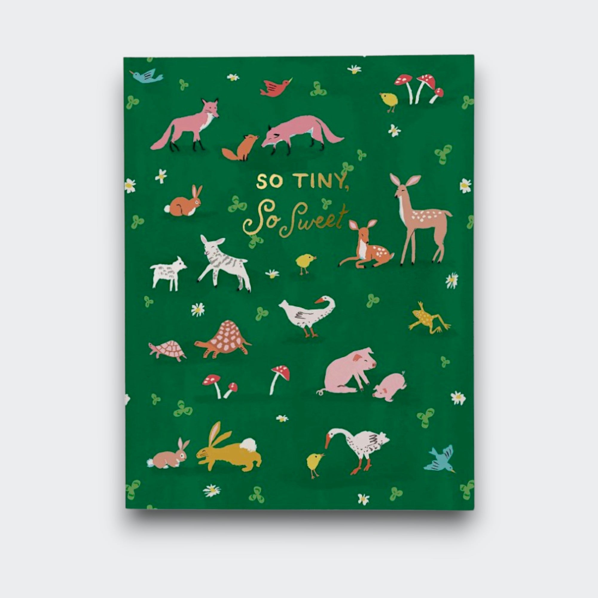 A dark green baby greeting card reading “So tiny, so sweet,” surrounded by small illustrations of woodland animals, birds, flowers, and mushrooms.