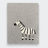 Little Moony folded gray knit baby blanket on a light gray background, with a black-and-white zebra design near the lower center.