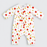 A white long-sleeve baby romper with an all-over fruit print of red apples, yellow bananas, and pink pears, featuring a snap-button front and chest pockets, shown on a light gray background.