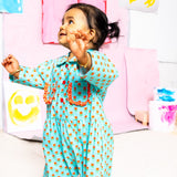 BABY GIRL IN LITTLE MOONY Rosebud Scallop Pocket Romper with colorful background