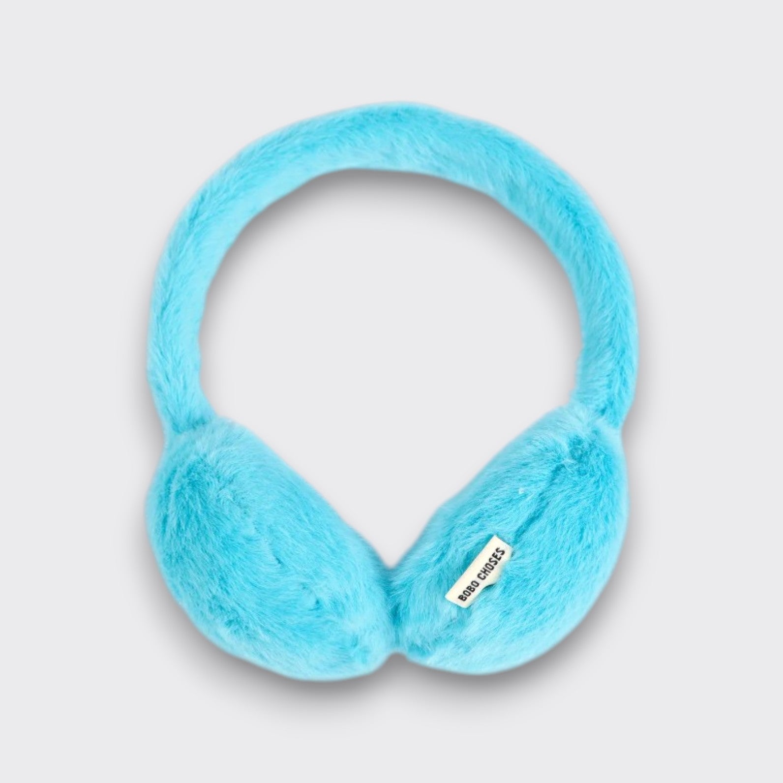 Front view of bright blue Bobo Choses faux-fur kids’ earmuffs, showing the padded ear covers on a light gray background.