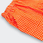 Close up detail of Little Moony cherry red polka dot baby pants showing cream dot print and elastic waistband