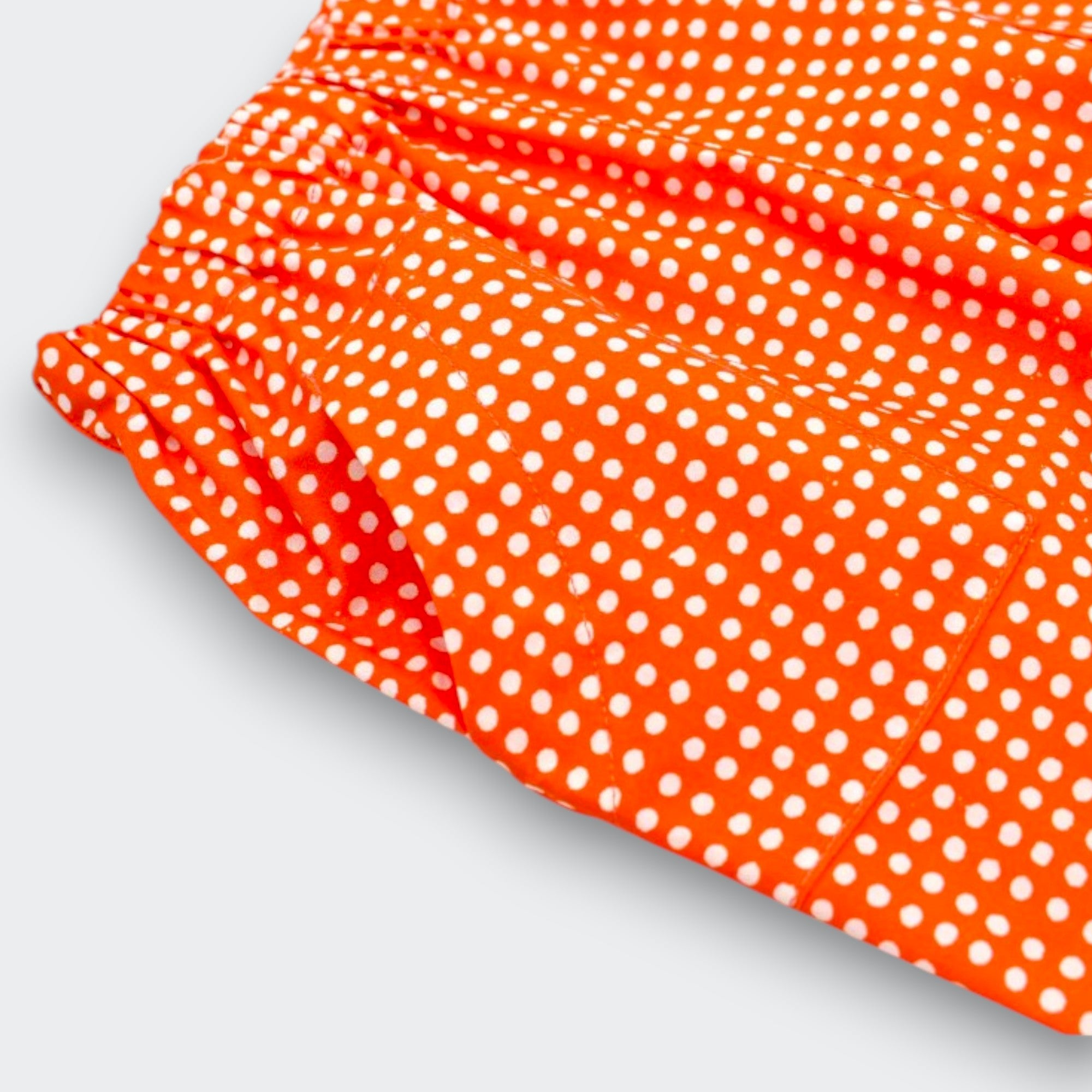 Close up detail of Little Moony cherry red polka dot baby pants showing cream dot print and elastic waistband