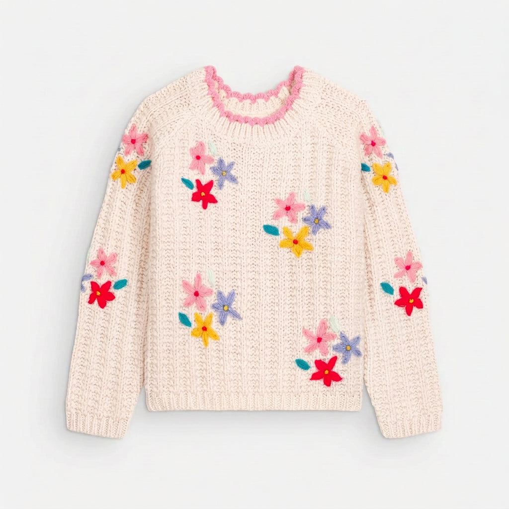 Cream knit sweater with colorful floral embellishments, pink neckline trim, and ribbed cuffs, shown from the front on a light gray background.