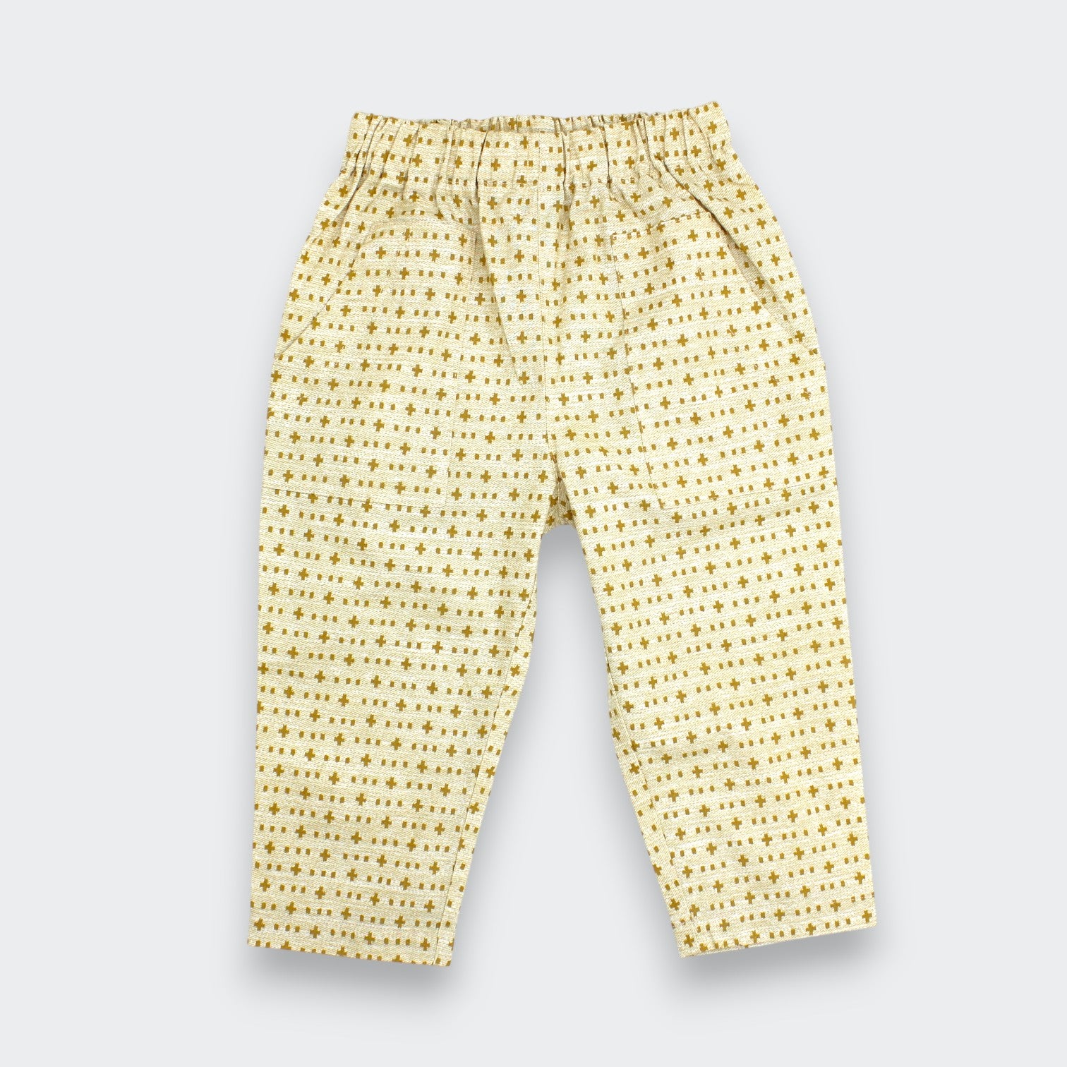Little Moony cream and brown cross-stitch print cotton baby and toddler pants flat lay view