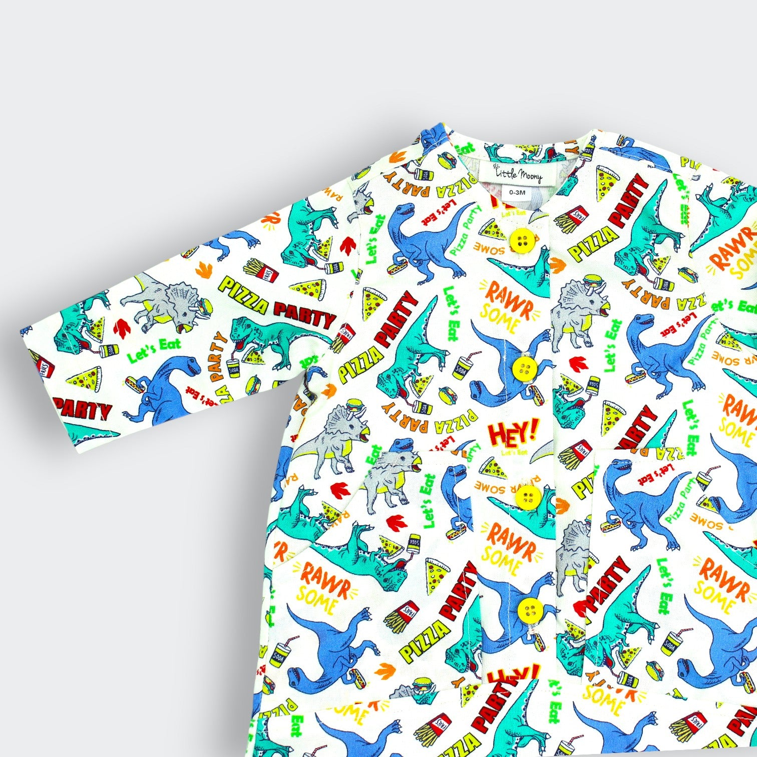 Close-up of dinosaur and pizza slice print on Little Moony white cotton baby jumpsuit

