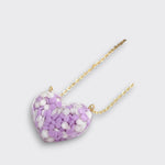 Little Moony Dotty Heart Necklace in Purple with confetti-filled resin heart and gold chain for kids laying down view