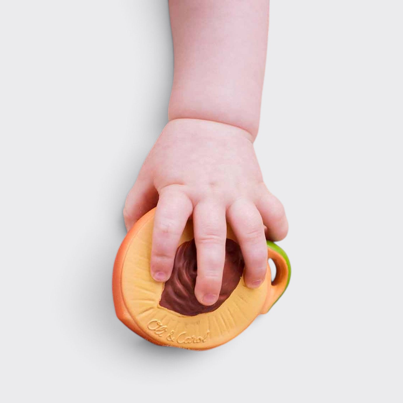 Little Moony Fruit Salad Newborn Pack with natural rubber peach holding by a babies hand.