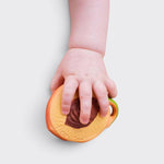 Little Moony Fruit Salad Newborn Pack with natural rubber peach holding by a babies hand.