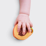 Little Moony Fruit Salad Newborn Pack with natural rubber peach holding by a babies hand.