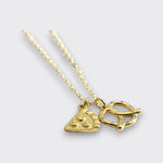 Angled view of a gold-tone necklace with pizza slice and pretzel charms on a light gray background.