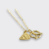 Angled view of a gold-tone necklace with pizza slice and pretzel charms on a light gray background.