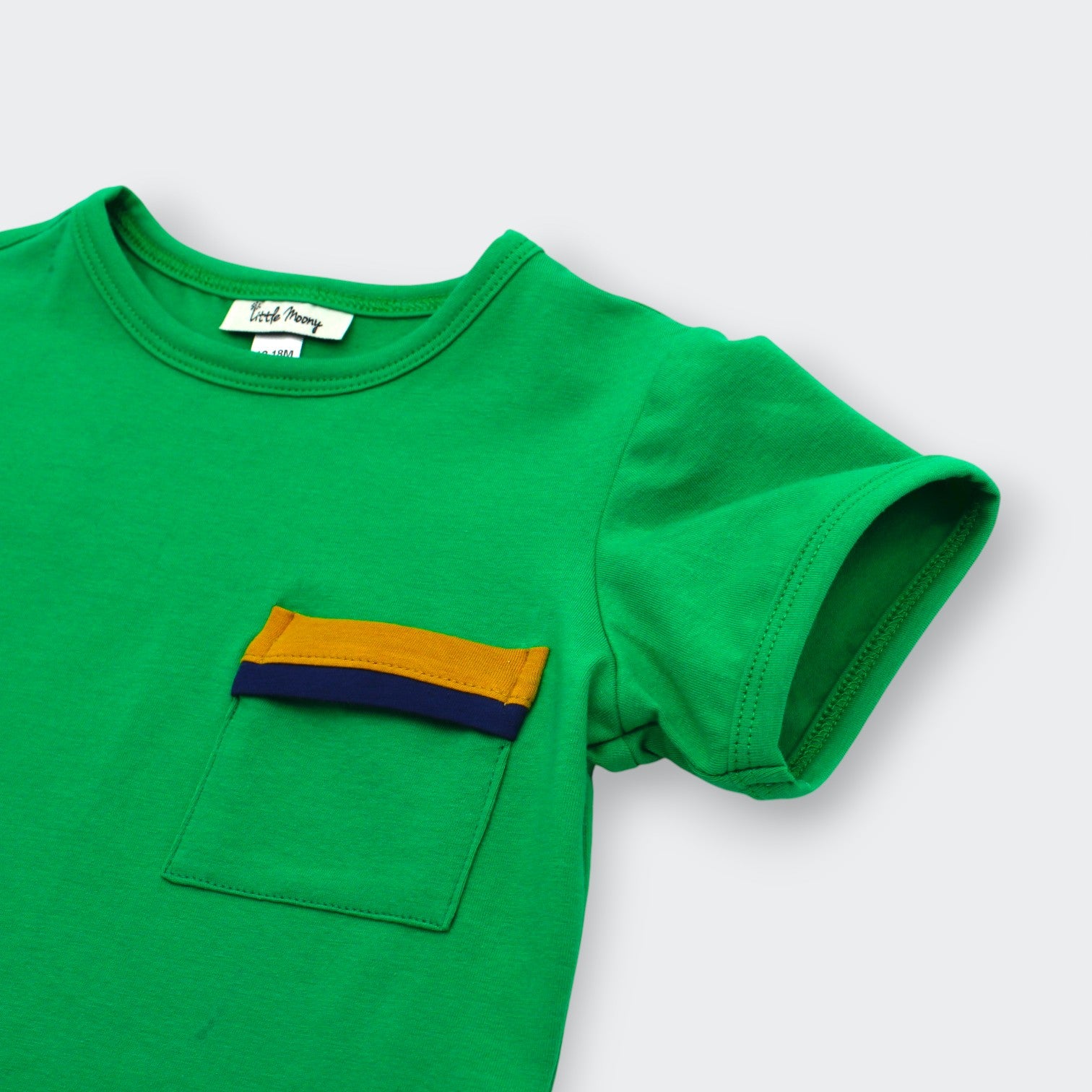 Close up of color blocked mustard yellow and navy pocket on Little Moony Jade Green Pocket Tee