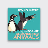 My First Pop-Up Endangered Animals children’s book by Owen Davey, with two illustrated penguins on a turquoise cover against a light gray background.