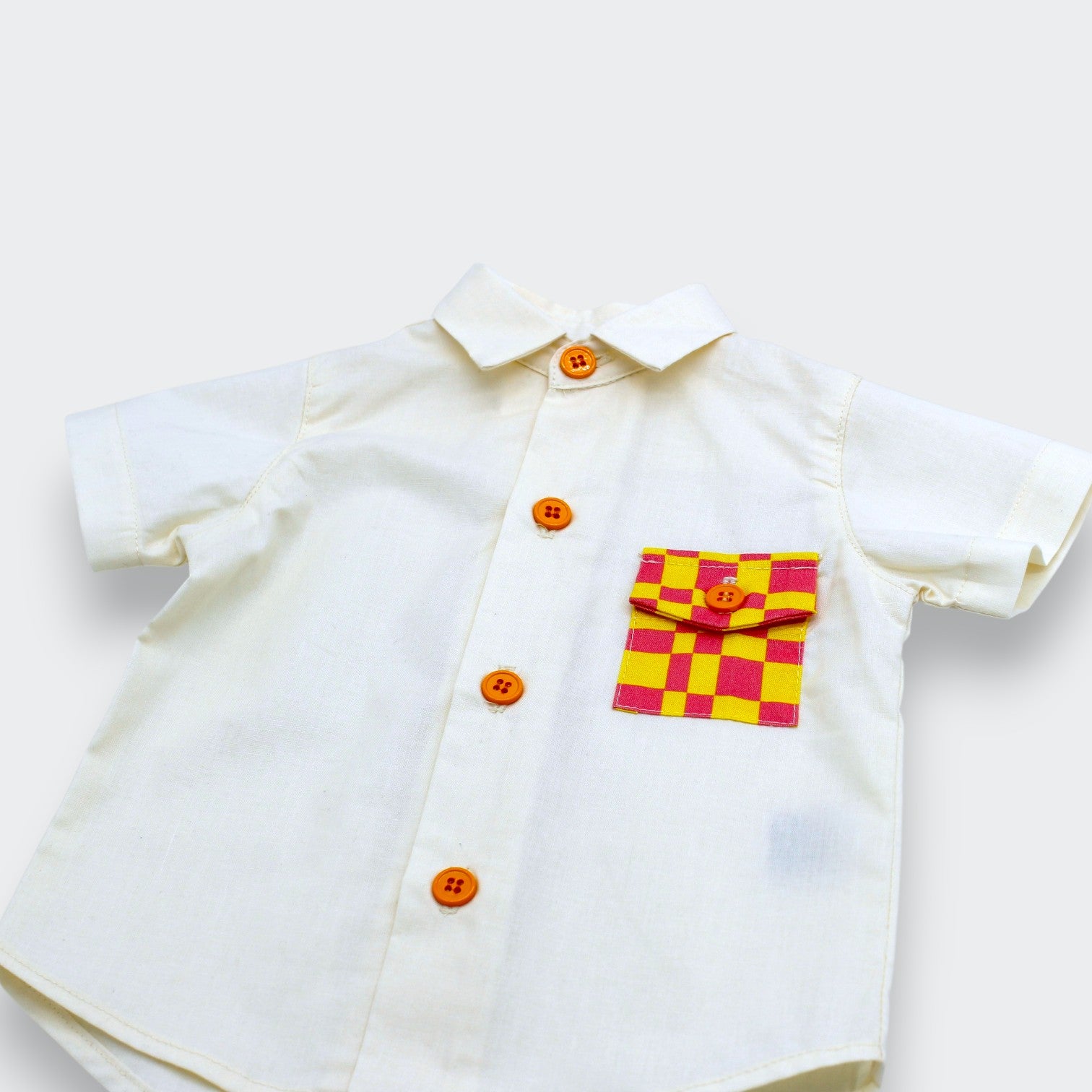 Little Moony Close-up of yellow and pink checkered pocket on Little Moony off white cotton button-up shirt
