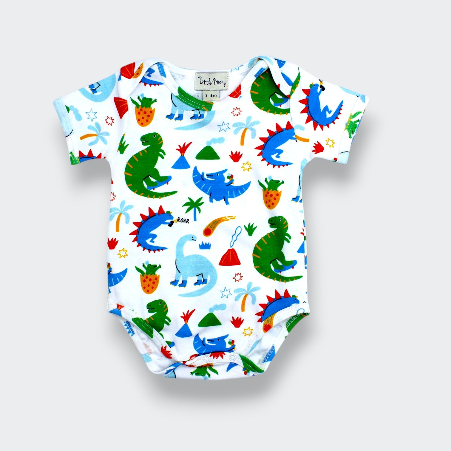 Little Moony organic Pima cotton dinosaur baby bodysuit with dino, volcano, palm tree, and comet print on white background