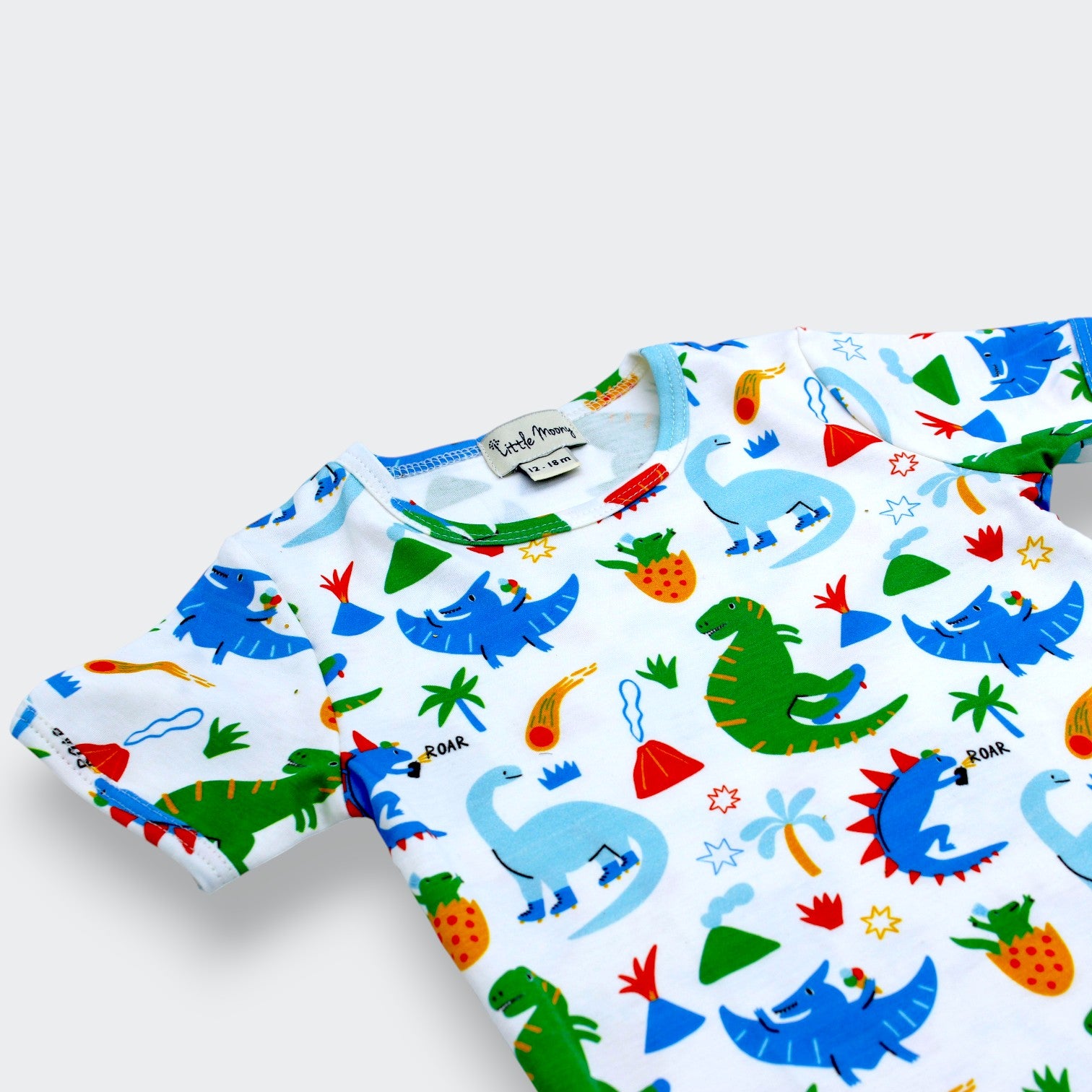 Close-up of dinosaur, palm tree, and comet print on organic Pima cotton kids T-shirt