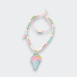 Pastel beaded necklace with a glitter ice cream cone pendant, pink flower detail, and pink cord on a light gray background.