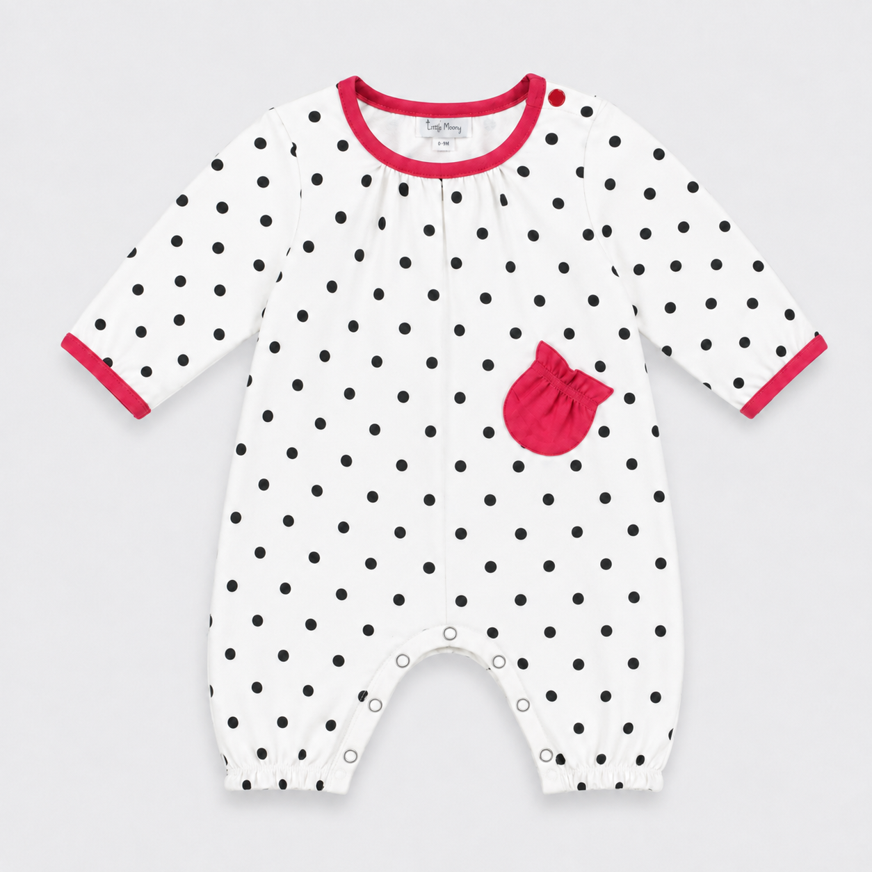 A baby long-sleeve footless romper in white with black polka dots, featuring a bright pink pocket and matching pink trim on the collar and cuffs, shown against a light gray background.