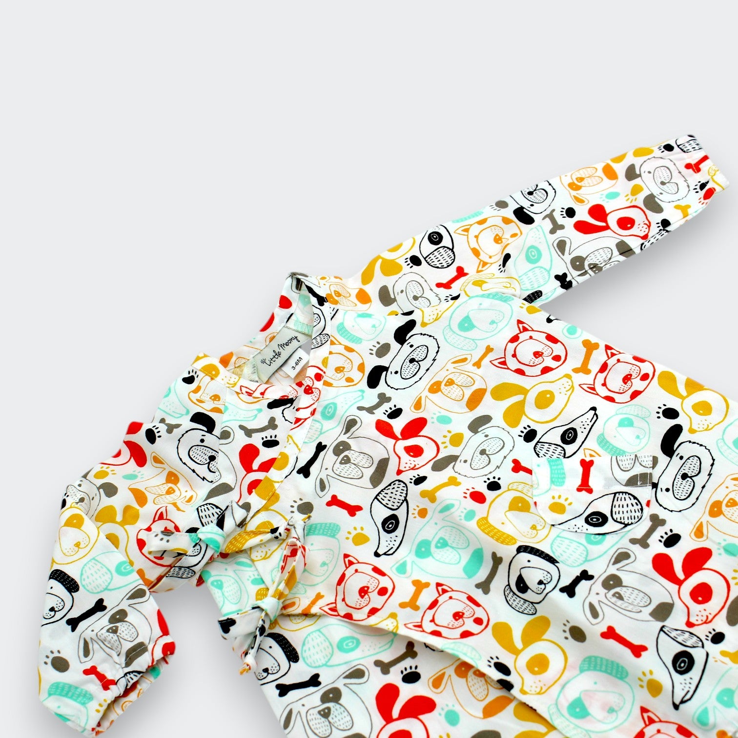 Close-up of charming puppy dog print with coral trim detail on Little Moony cotton baby kimono one-piece