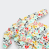 Close-up of charming puppy dog print with coral trim detail on Little Moony cotton baby kimono one-piece