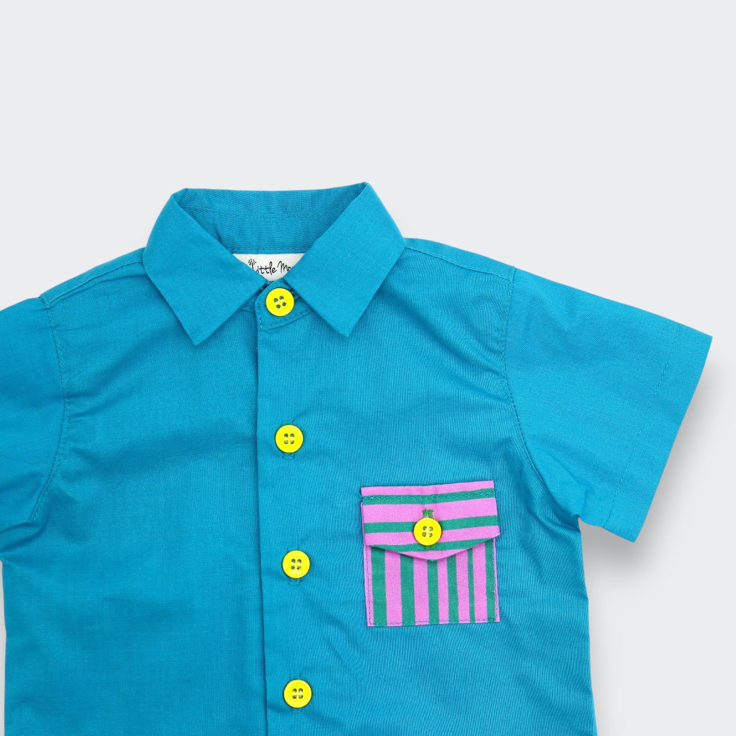 Close up detail of Little Moony teal cotton button up baby shirt showing point collar and yellow buttons