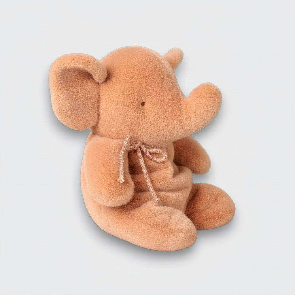 Side view of a vintage rose elephant plush toy with an upturned trunk, large ears, and a matching neck bow on a light gray background.