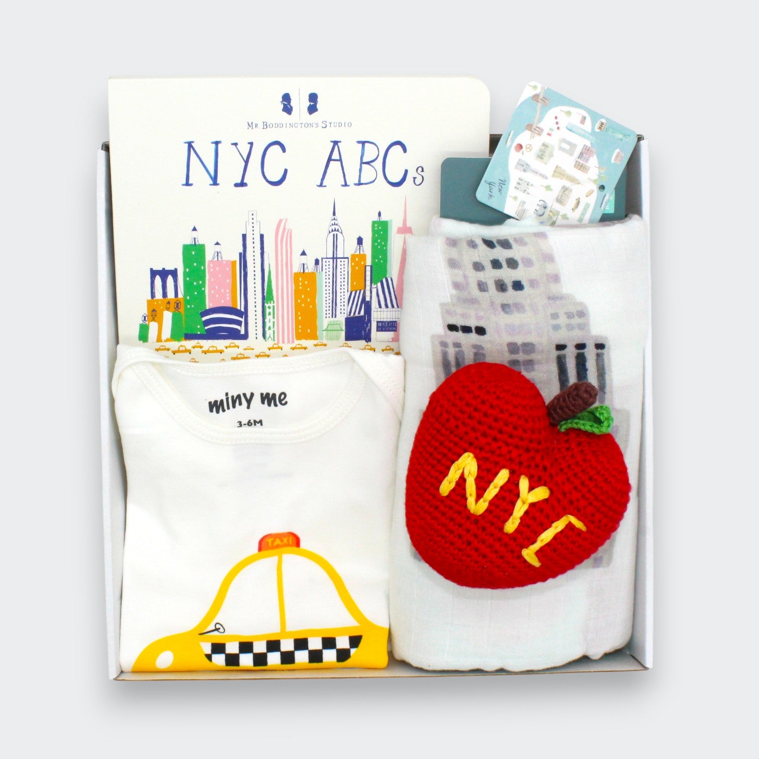 New York Taxi baby gift set featuring organic cotton taxi onesie, NYC ABC board book, New York City swaddle, and apple rattle